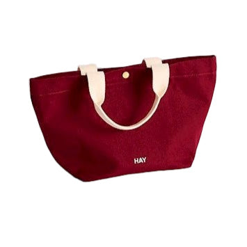 Burgundy tote bag with white handles on a white background