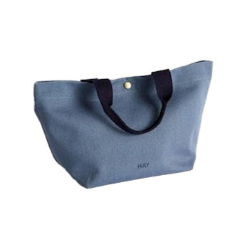 Blue tote bag with black handles on a white background