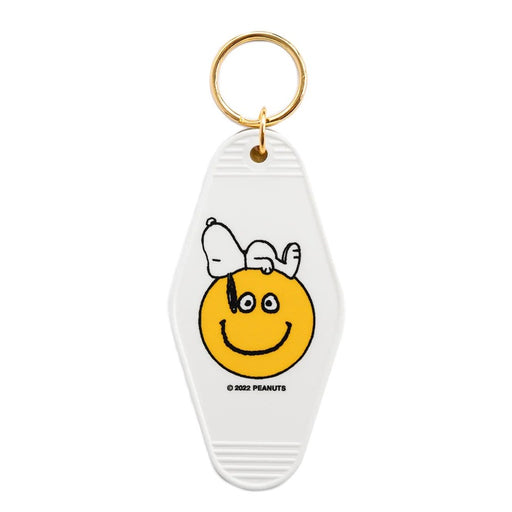 Keychain with a smiley face design and Snoopy on a white background