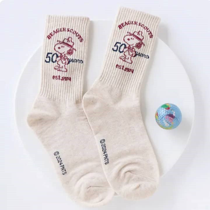 Two beige socks with red graphics and text on a white plate.