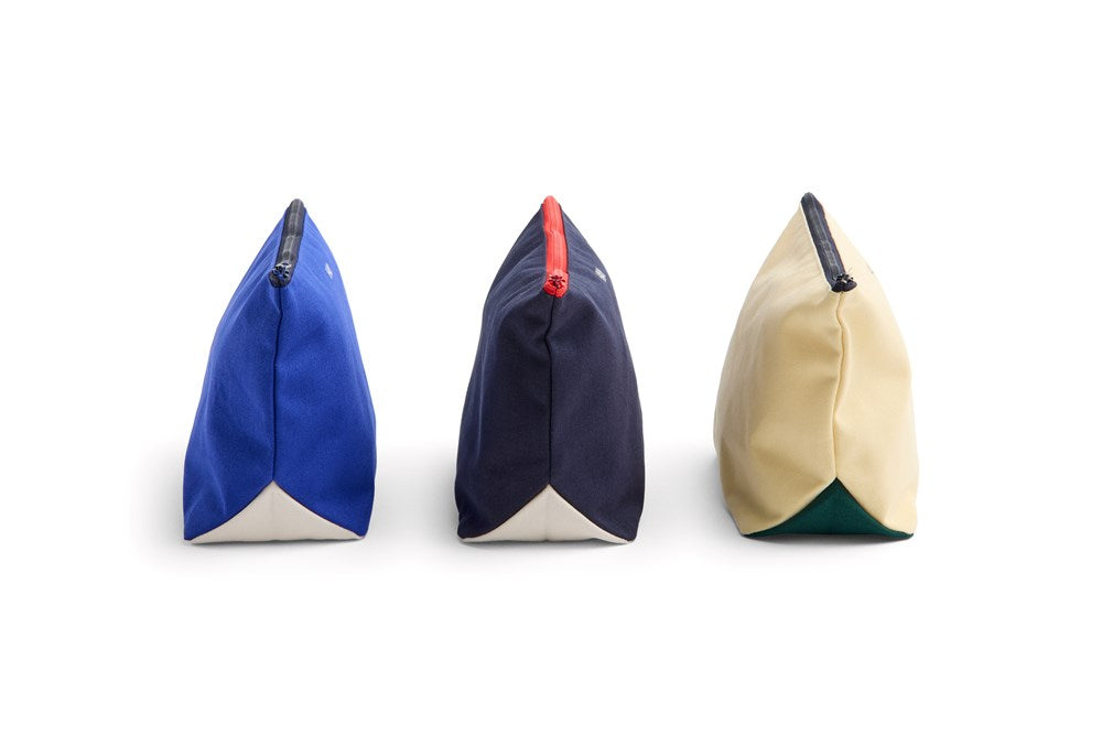 Three triangular pouches in blue, navy, and beige on a white background