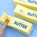 Three blocks of salted butter squishy stress toys on a blue background