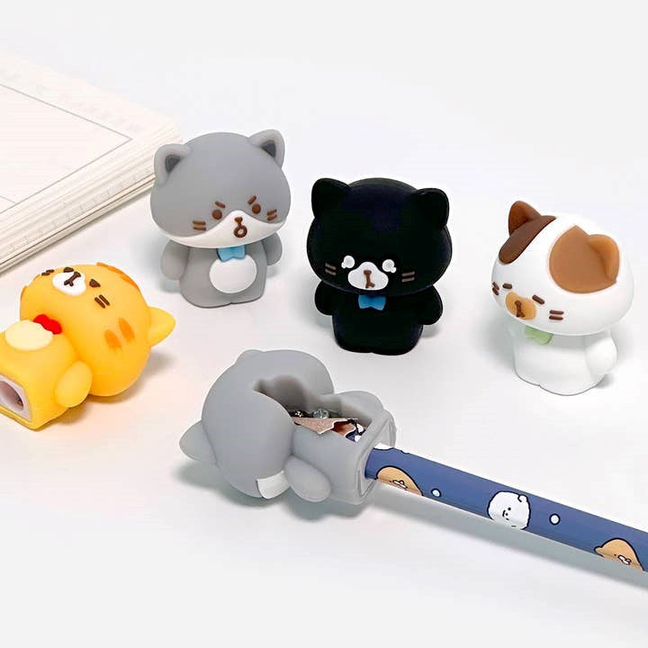 Set of cartoon cat-shaped pencil sharpeners on a white background
