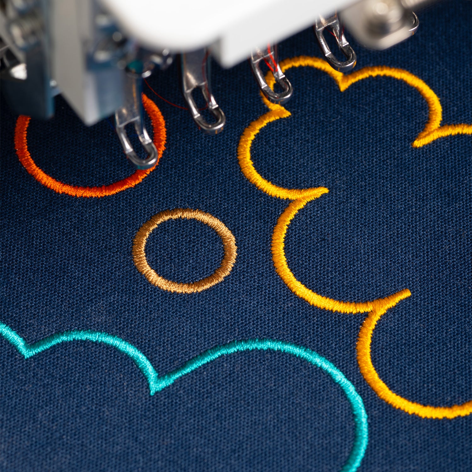 Embroidery machine stitching colorful designs on fabric