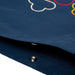 Close-up of a button on a navy blue fabric with colorful embroidery in the background.