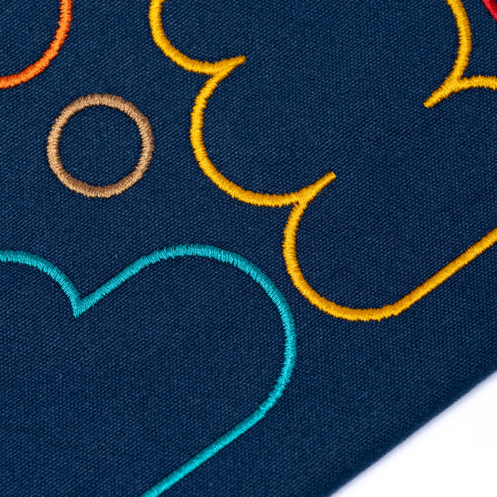 Close-up of embroidered colorful patterns on dark fabric