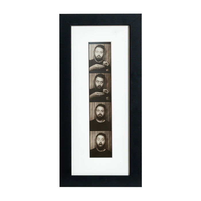 A black photobooth frame displaying a photo strip of multiple faces.