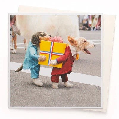 A greeting card featuring two dogs dressed in costumes, one in blue and the other in red, carrying a package in the manner of delivery drivers.