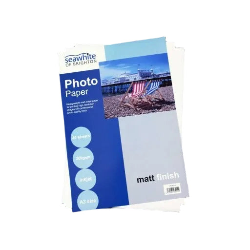 A stack of Seawhite Matt Photo Paper - A4 size, 200gsm, with 25 sheets, displayed with a cover showing an image of a beach scene.